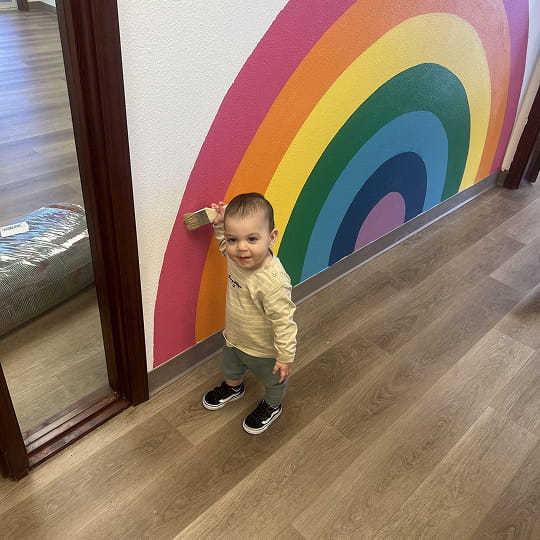 A toddler is drawing a wall